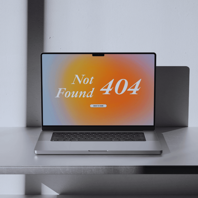 Close-up of a MacBook Pro laptop screen with a 404 error page. The page has a blurry, orange and light blue gradient background and the text 'Not Found 404'.