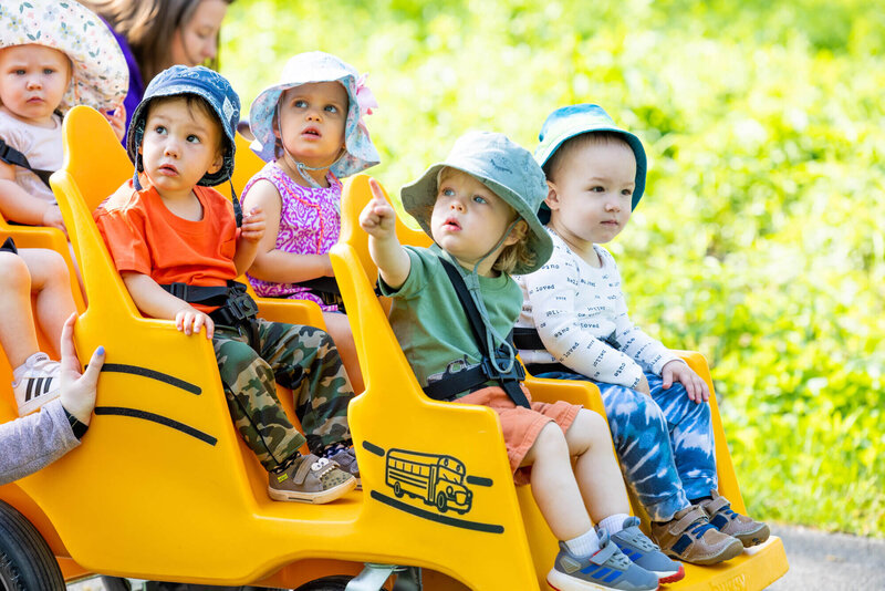 toddlers going for a buggy ride outside at daycare