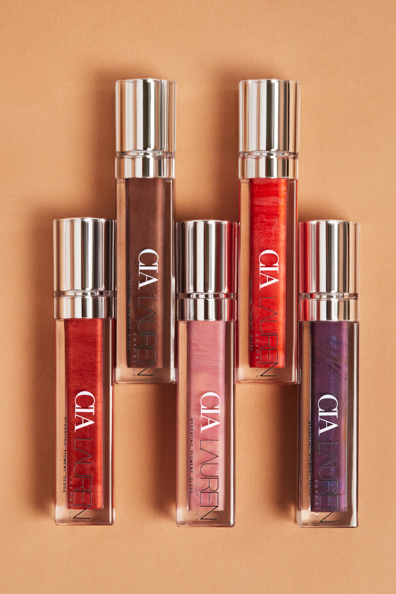 Cia Laura lip gloss collection in various shades, with sleek packaging and vibrant colors, photographed by Ylva Erevall.