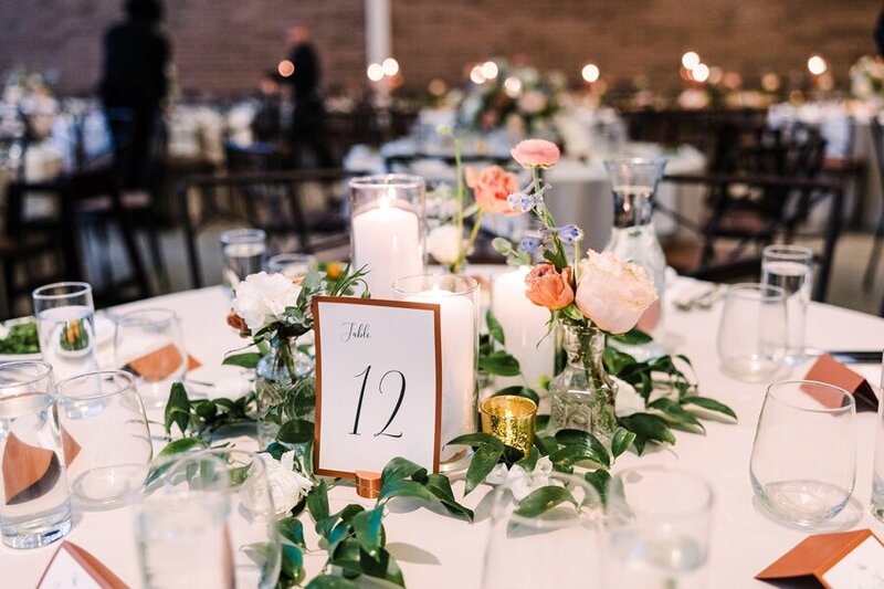 Wedding reception table with greenery, candles, and delicate florals, styled by a wedding planner in Austin for an inviting atmosphere.