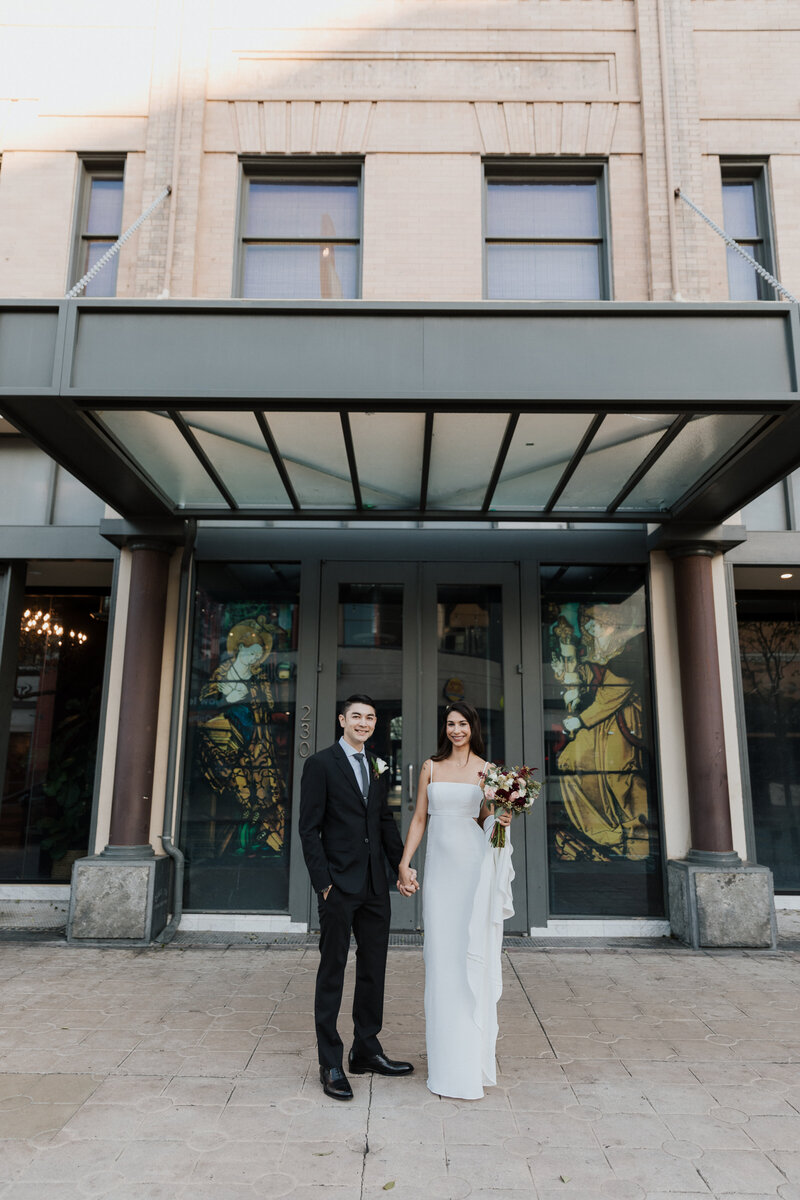 Erika and Dylan outside a modern city venue during their wedding, coordinated by Beyond the Event and photographed by Coyprint.