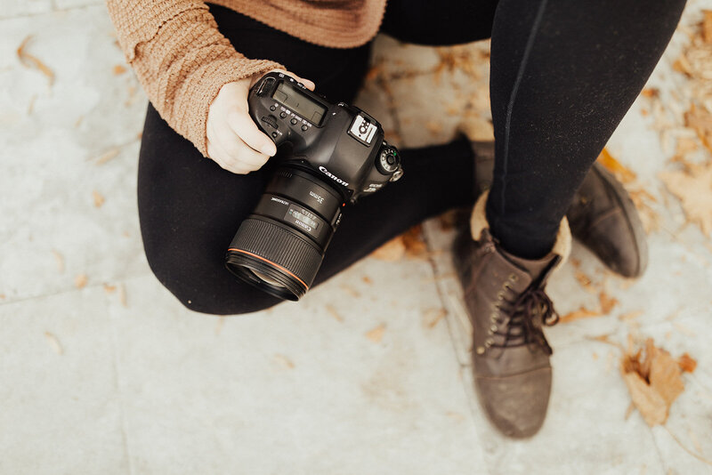 photographer wearing boots holding camera