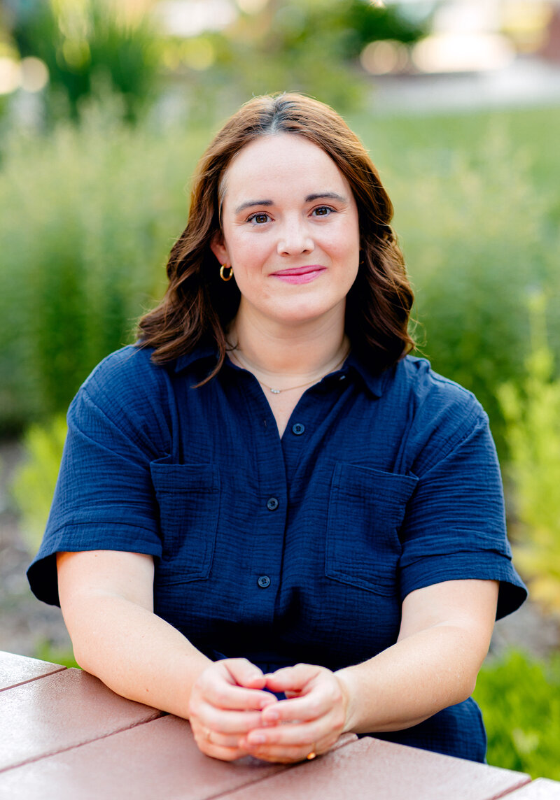 Outdoor professional headshot of a client seated and smiling at the camera.
