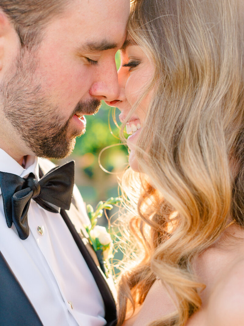 An intimate, sunlit close-up of a bride and groom sharing a joyful moment, captured by Elizabeth Kane, a fine art wedding photographer serving Philadelphia, New York, and beyond.