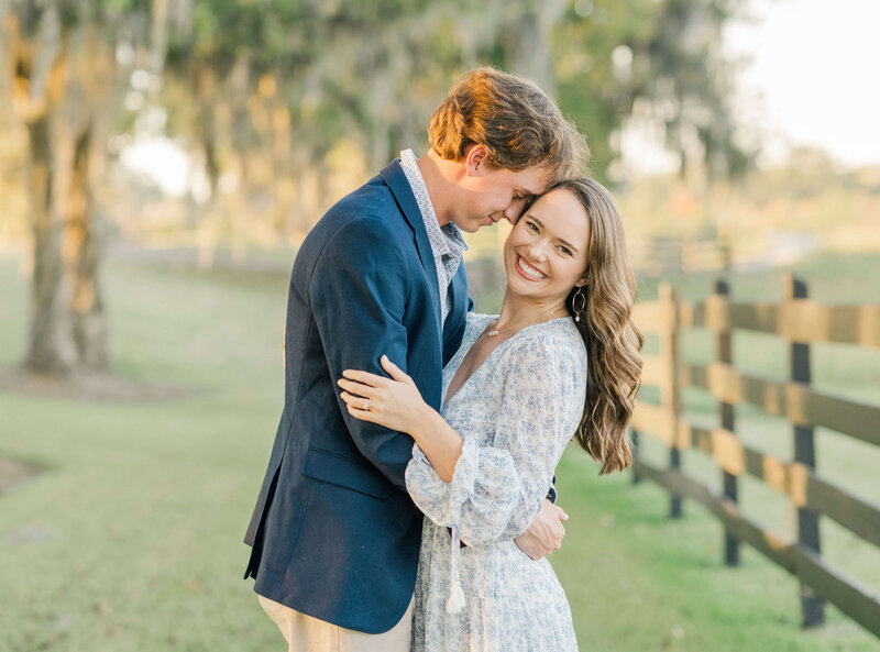 Engaged couple hugging each other and girl looking at camera