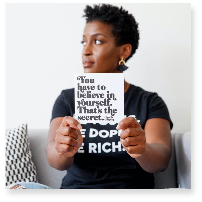 Woman holding a sign that reads You have to believe in yourself. That's the secret.