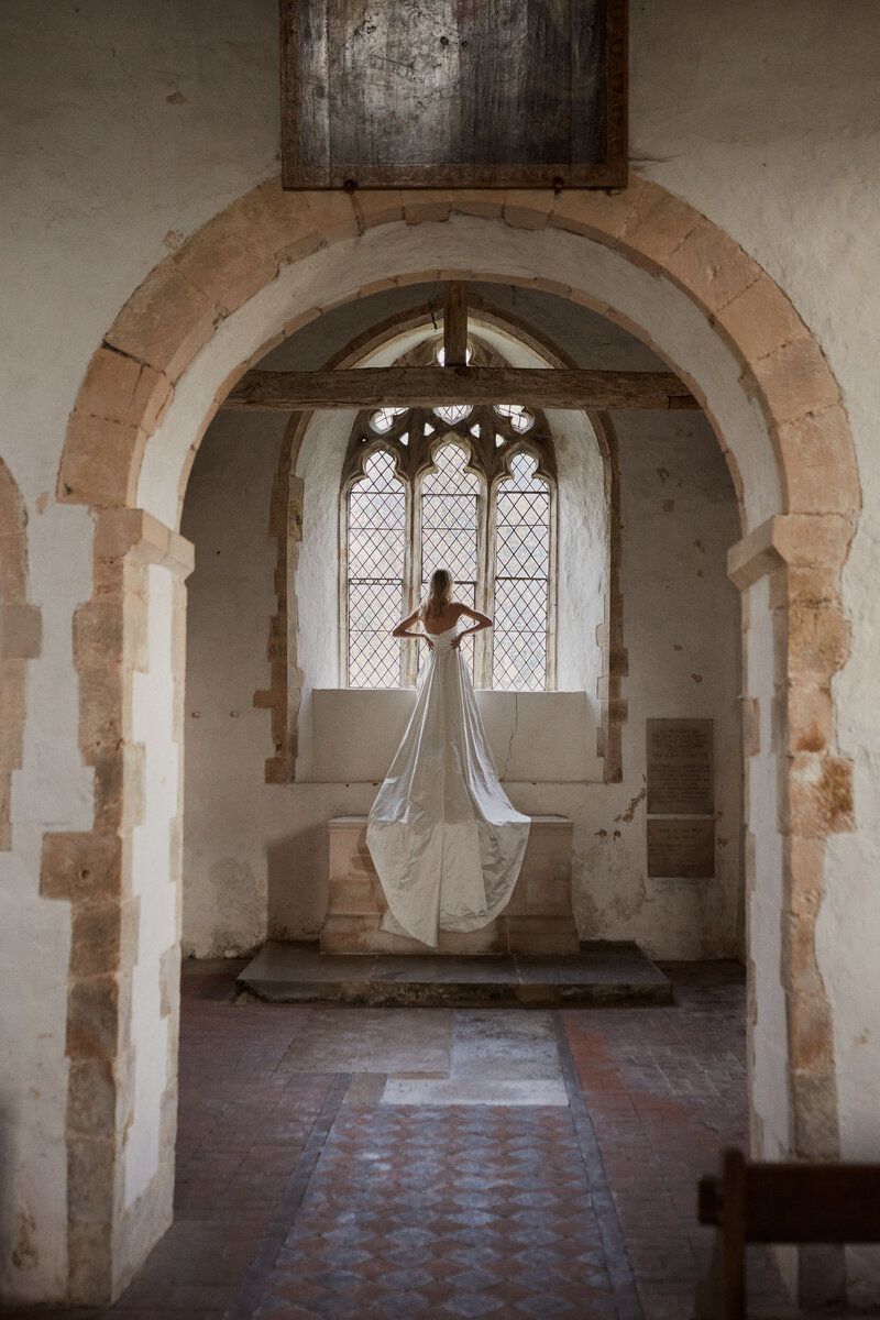 Handmade silk wedding dress, corset-style, long worn by bride in chapel