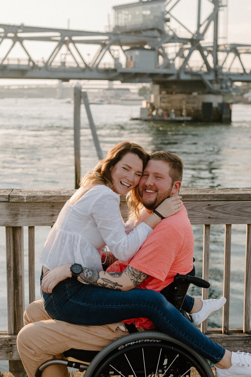 bride and groom in wheelchair smiling by ocean