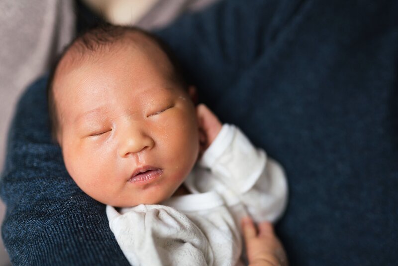 baby in father's arm during Seattle newborn photography session