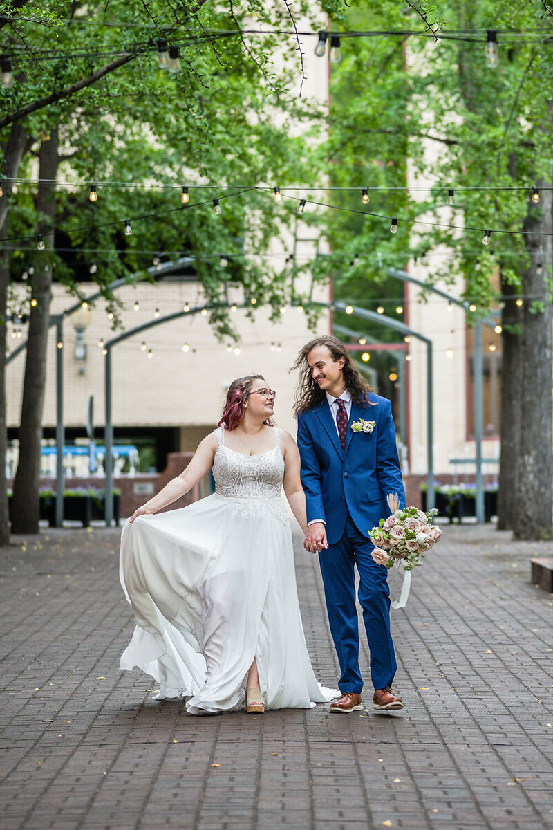 A bride and groom walk hand-in-hand in an alley in Downtown Roanoke following their ceremony on their elopement day.