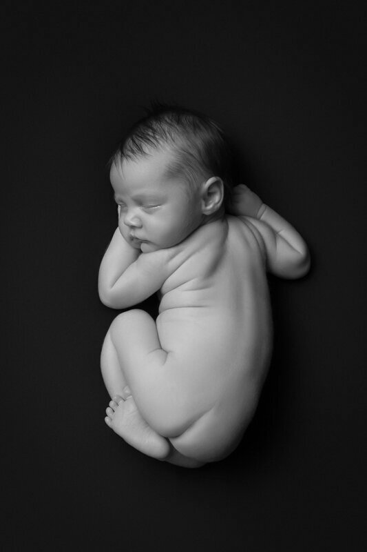 black and white naked newborn baby photographed from above by Charlotte newborn photographer Alicia Insley Smith