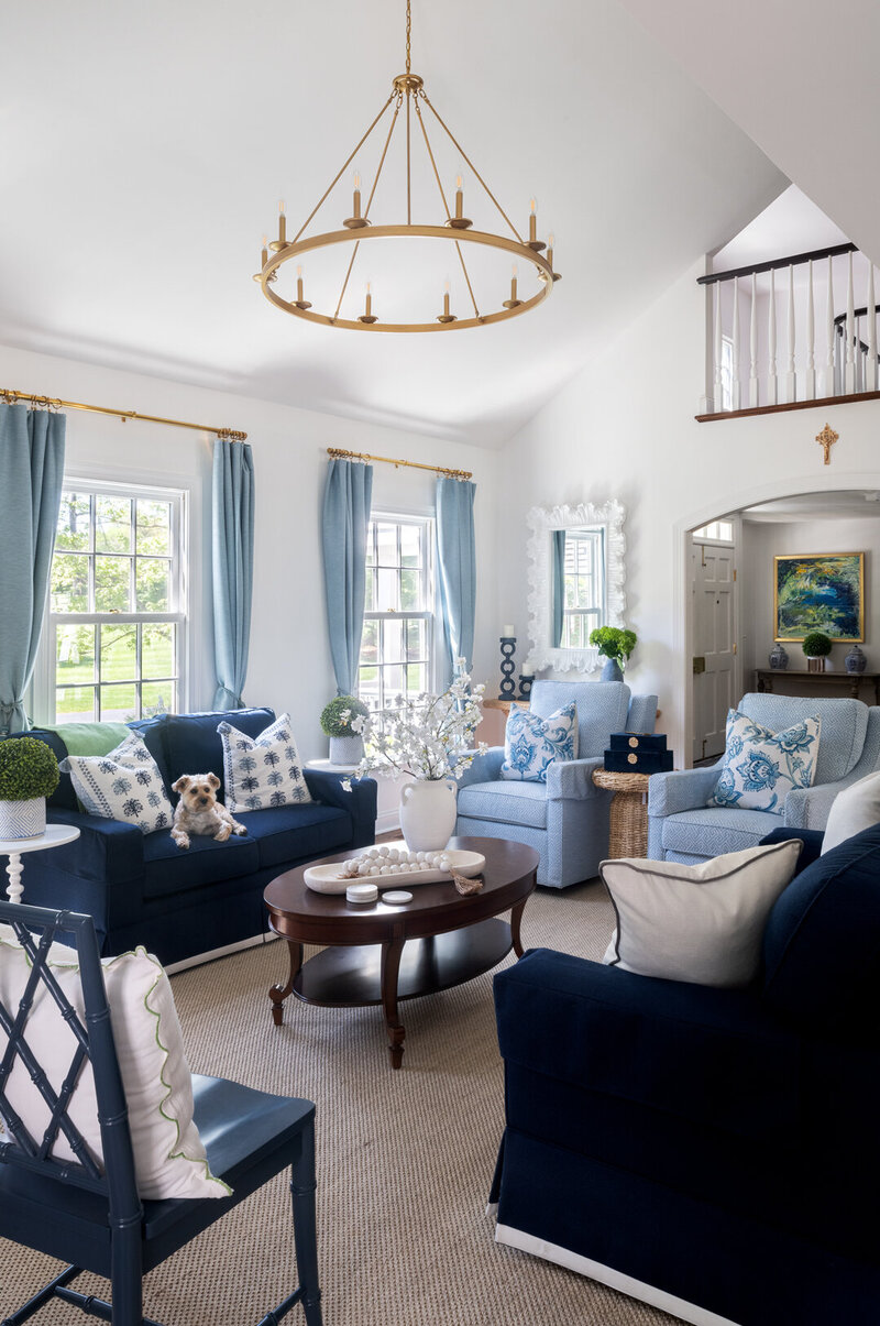 bright white living room with dark navy accent chairs and couch and bright blue accents