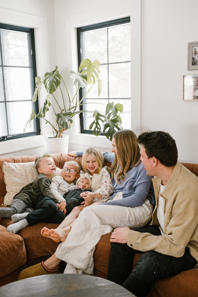 Kiana Grant with her four young children in a casual outdoor setting, smiling and interacting.