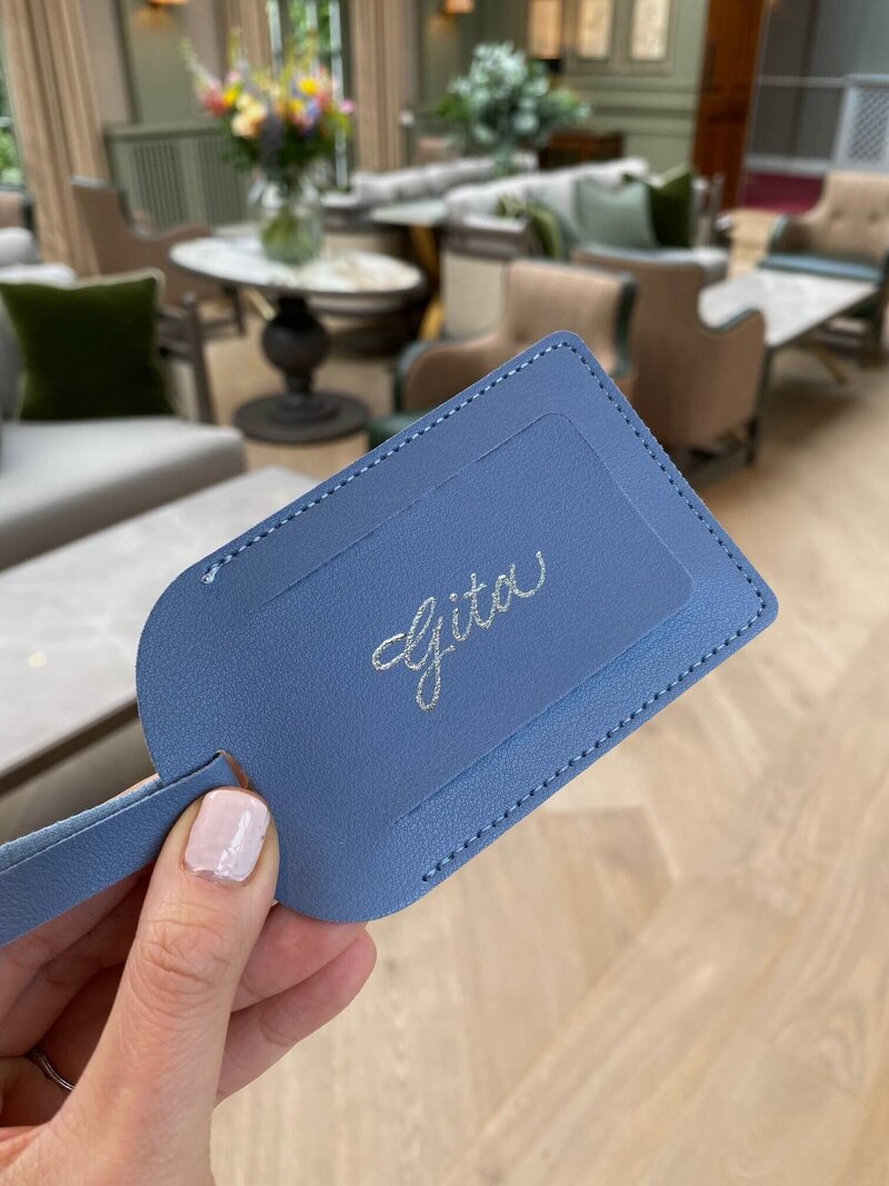 blue luggage tag with silver writing