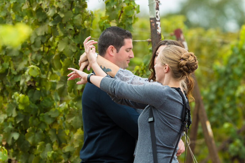 Jen Stitt demonstrating a picture-perfect pose for an engaged couple during their engagement session, showcasing her creativity and expertise in guiding couples to create stunning and memorable photos.
