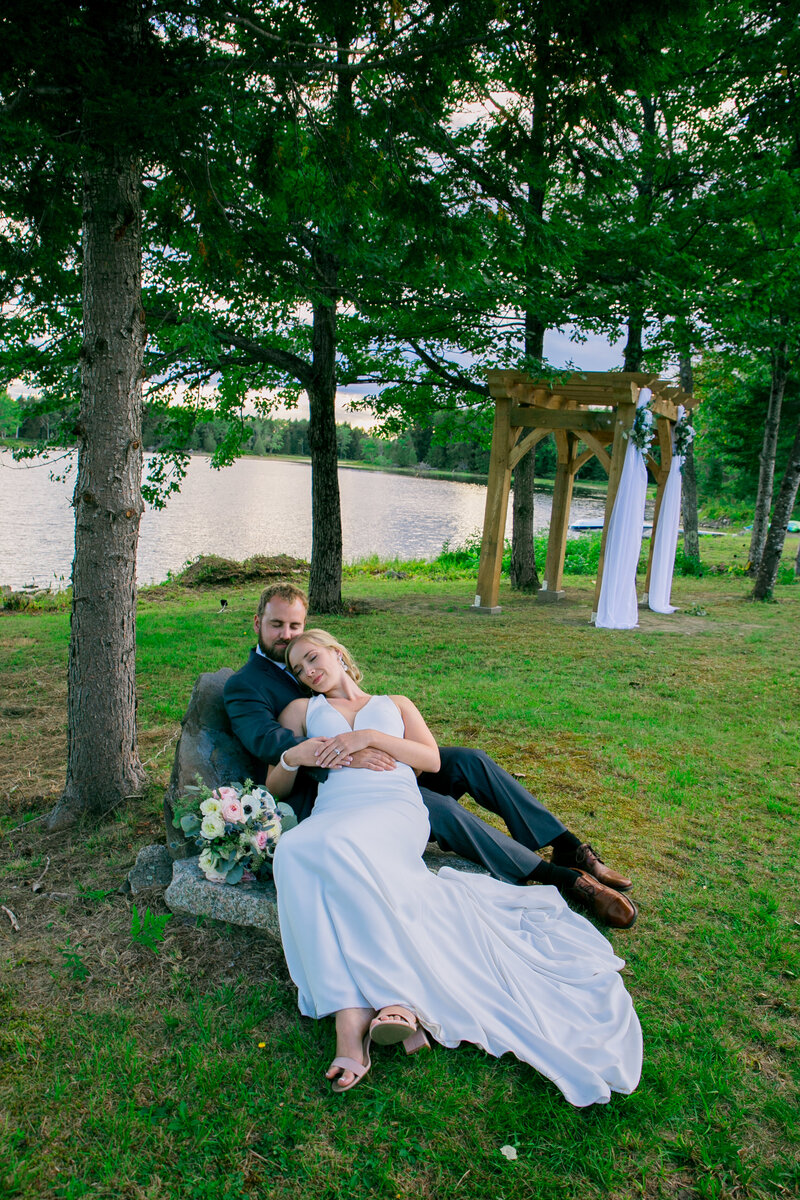 Bride and groom sitting on ground, Groom holding bride in arms | Wedding Photography