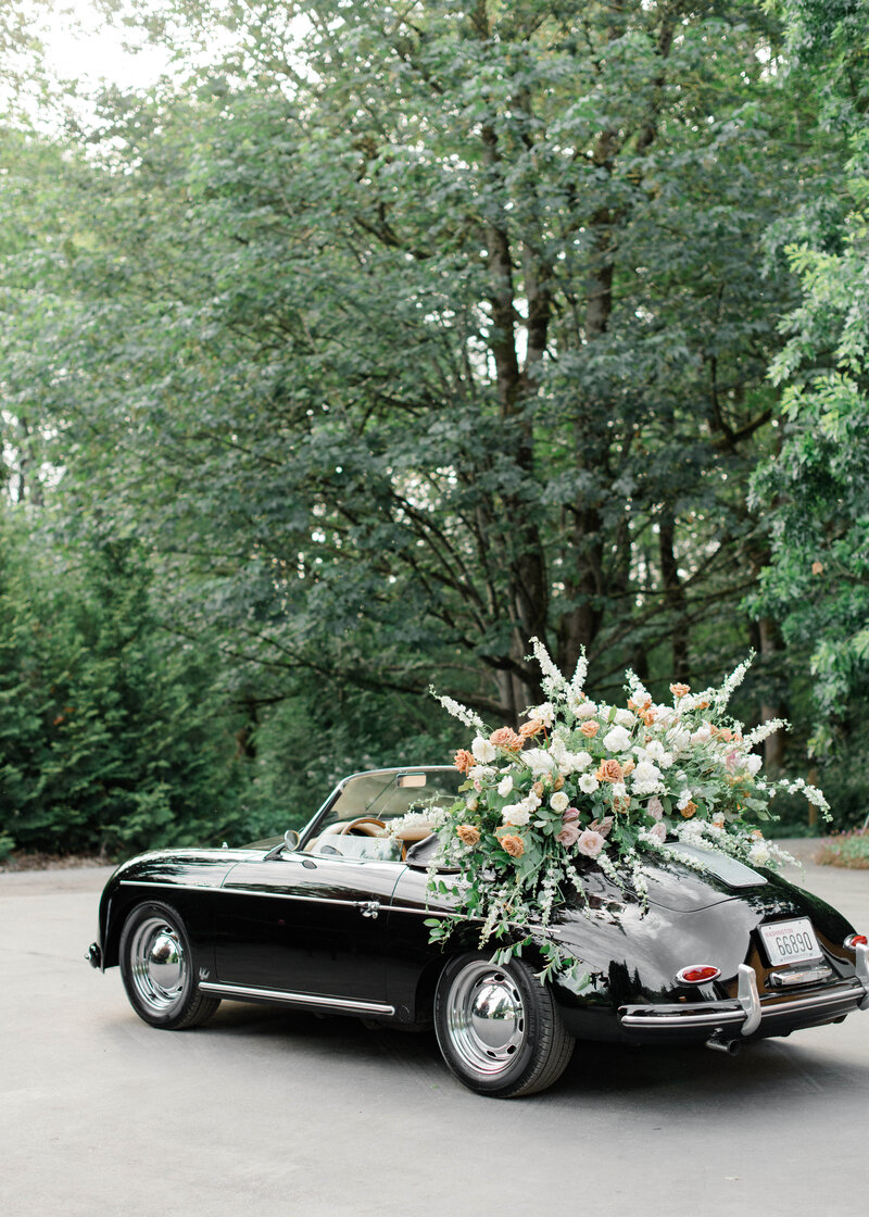 Lush floral installation on back of vintage luxury convertible car