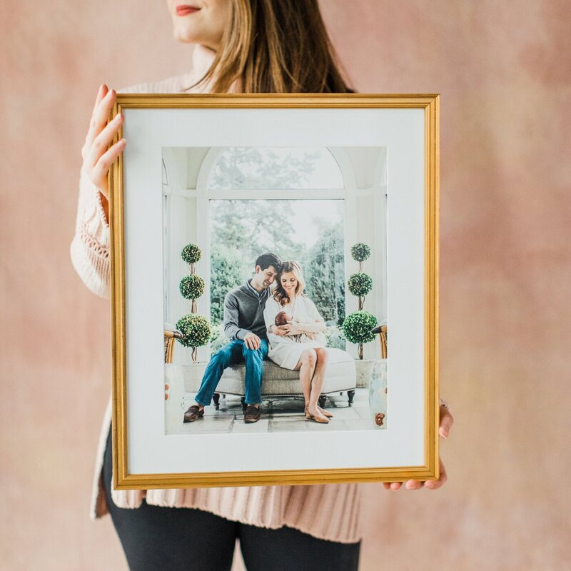 gold frame held in front of a blush pink backdrop