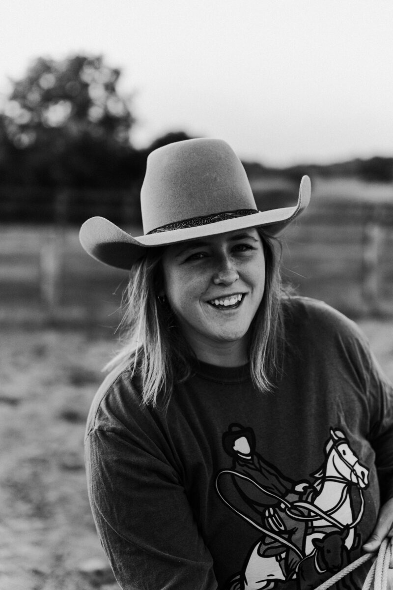 a black and white image of a cowgirl wearing a cowboy hat