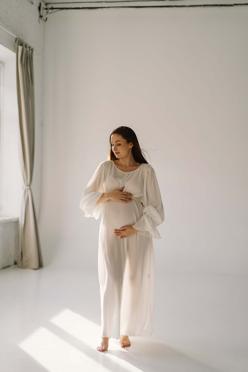 cute-young-pregnant-girl-sitting-white-studio-warm-light (2) (1)