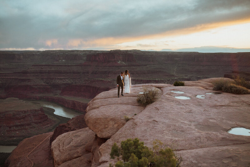 A couple eloping in Moab Utah overlooking the canyon floor at Dead Horse State Park
