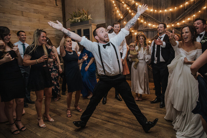 A person dancing in the middle of a circle at a wedding reception