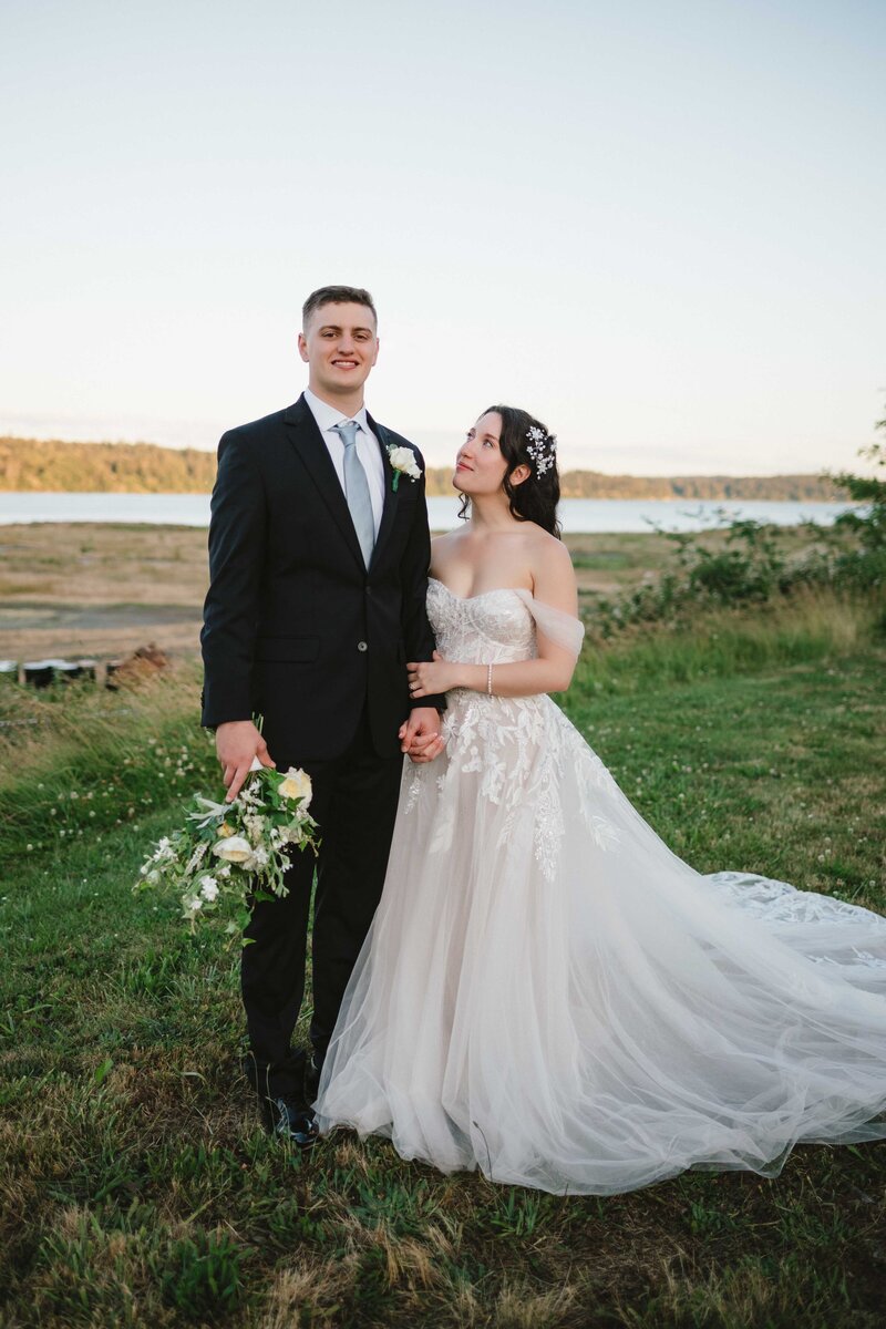 Bride and groom pose for their wedding portrait framed by large wood carving at Willows Lodge in Woodinville, WA.