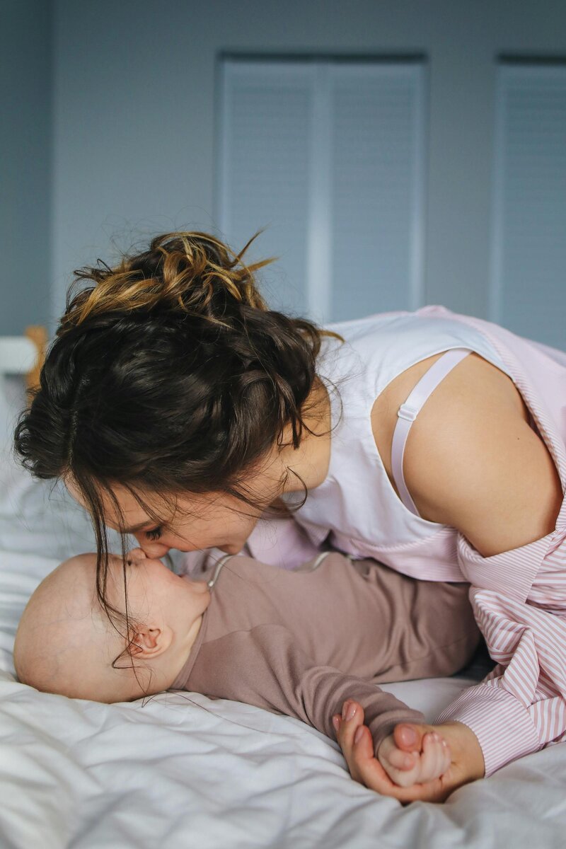 mom playing with baby and laughing ini face