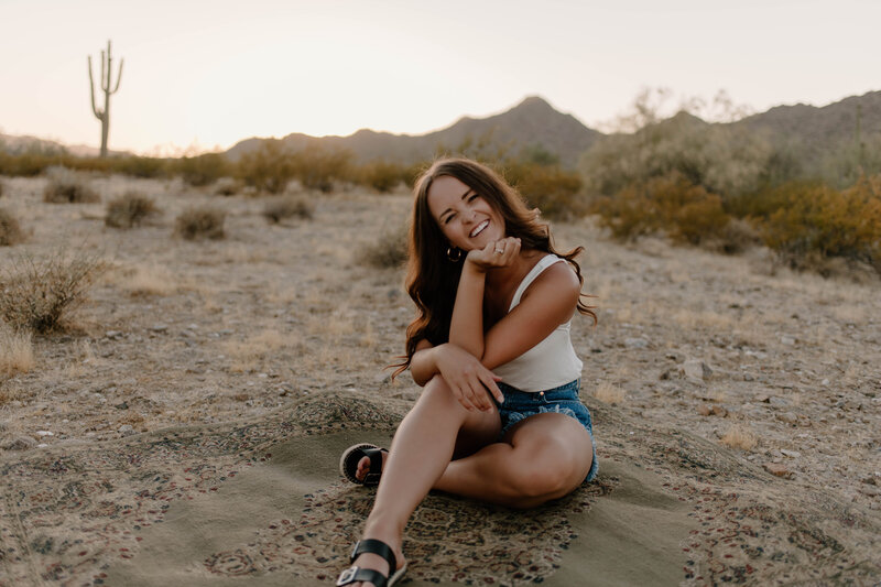 Girl sitting in the desert smiling