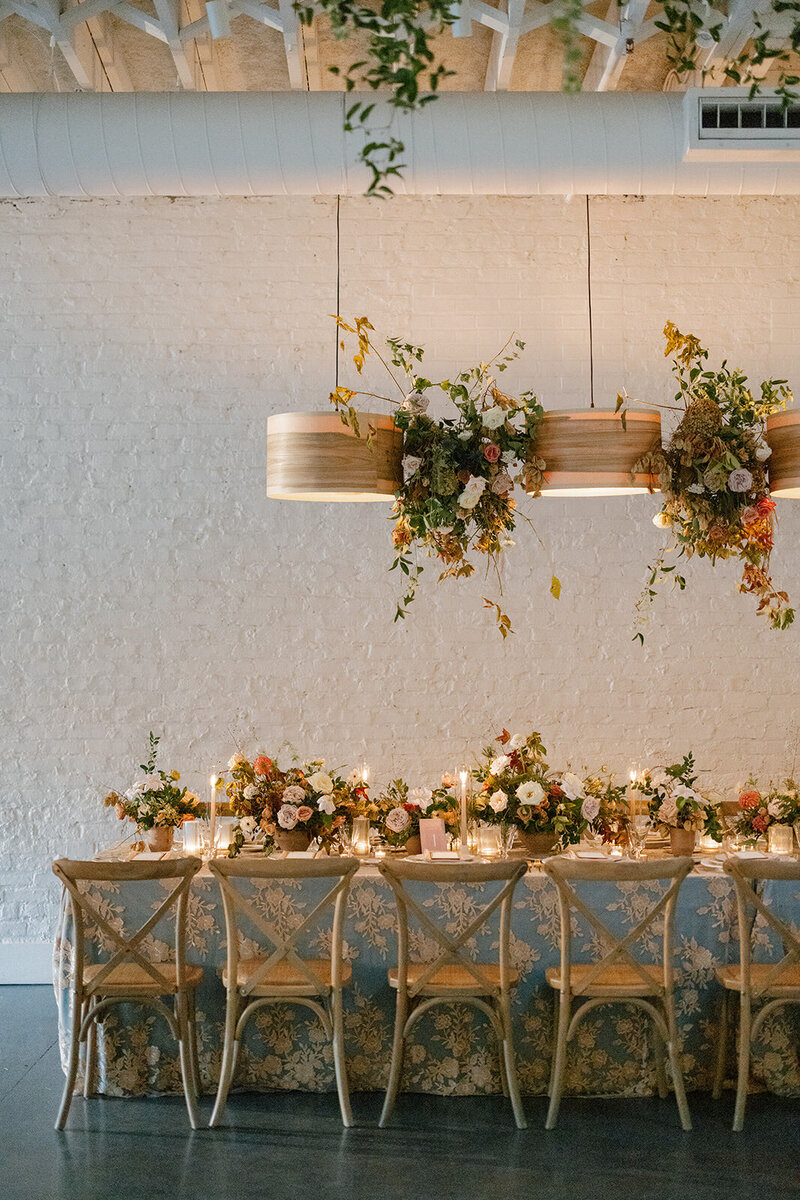 Floral Chandelier hanging floral clouds accent fall wedding reception in Raleigh, NC with roses, hydrangeas, and fall branches in colors of mauve, copper, cream, dusty pink, and green. Design by Rosemary and Finch Floral Design in Nashville, TN.
