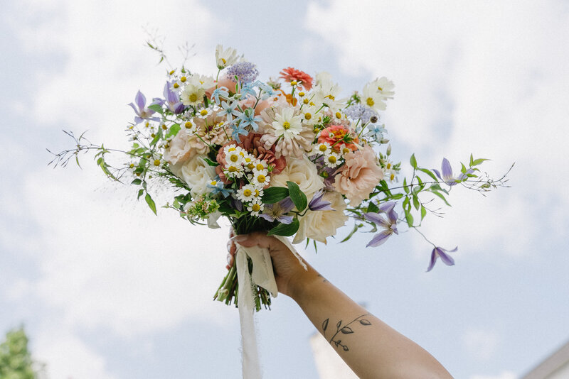 Flowers held against a blue sky