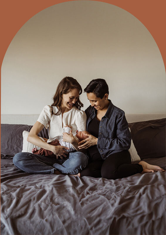 two lesbian mothers cradle their newborn