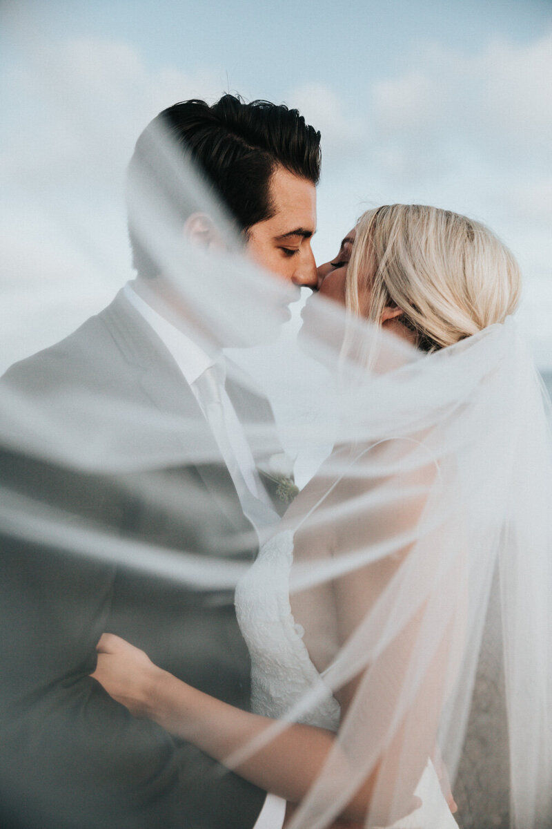 Couple about to kiss with veil