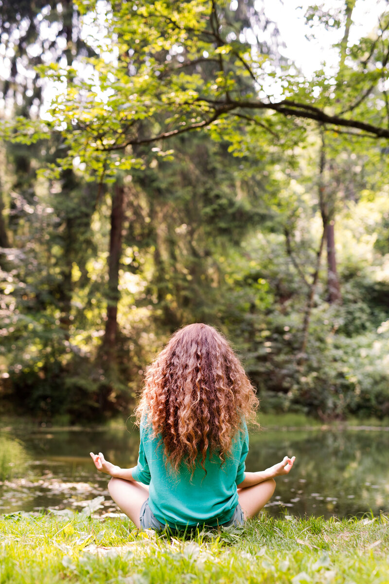 Woman meditating by a river