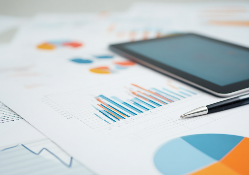 paper with charts with pen on it