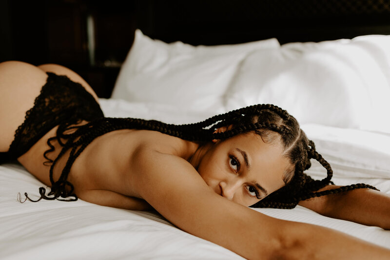 african american woman laying on a bed in black lingerie