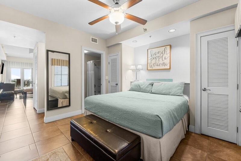 beach people welcome sign over king bed with blue bedding