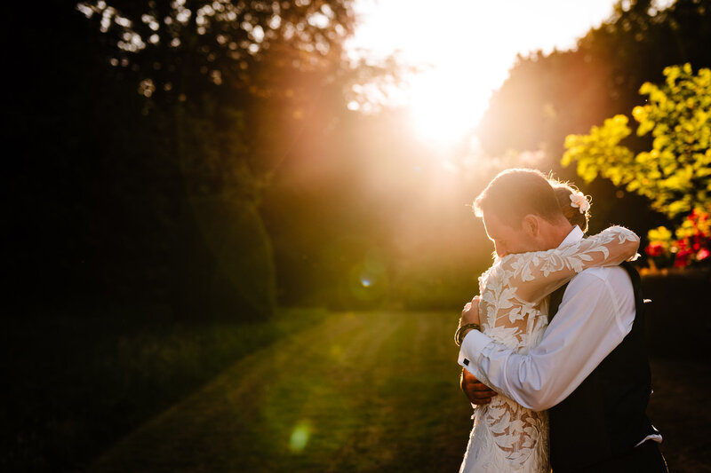 Groom giving bride a piggyback ride at outdoor reception