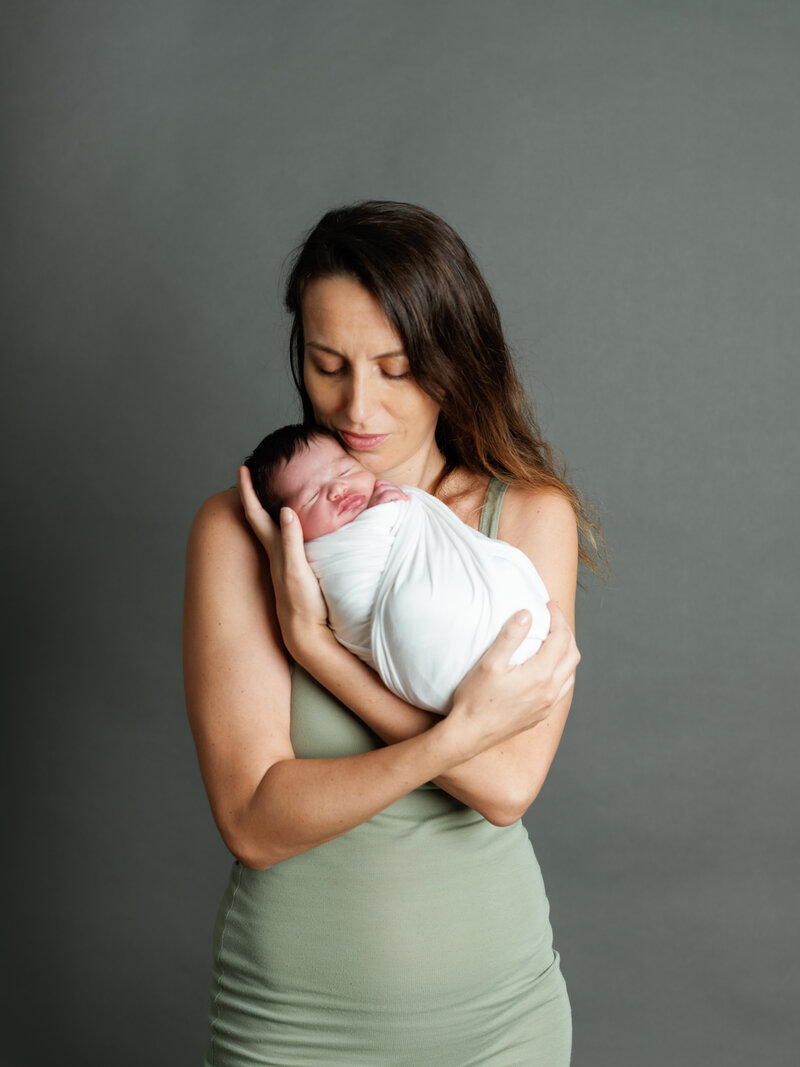 Maman et Moi : portrait avec le bébé en studio pro sur fond noir, robe de la maman couleur olive