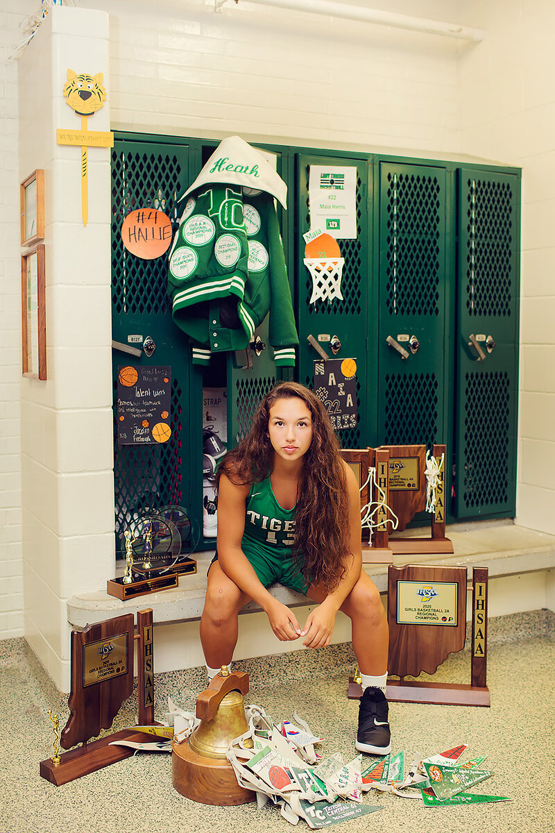 Taylor in the locker room at Triton Central with all of her trophies for basketball!