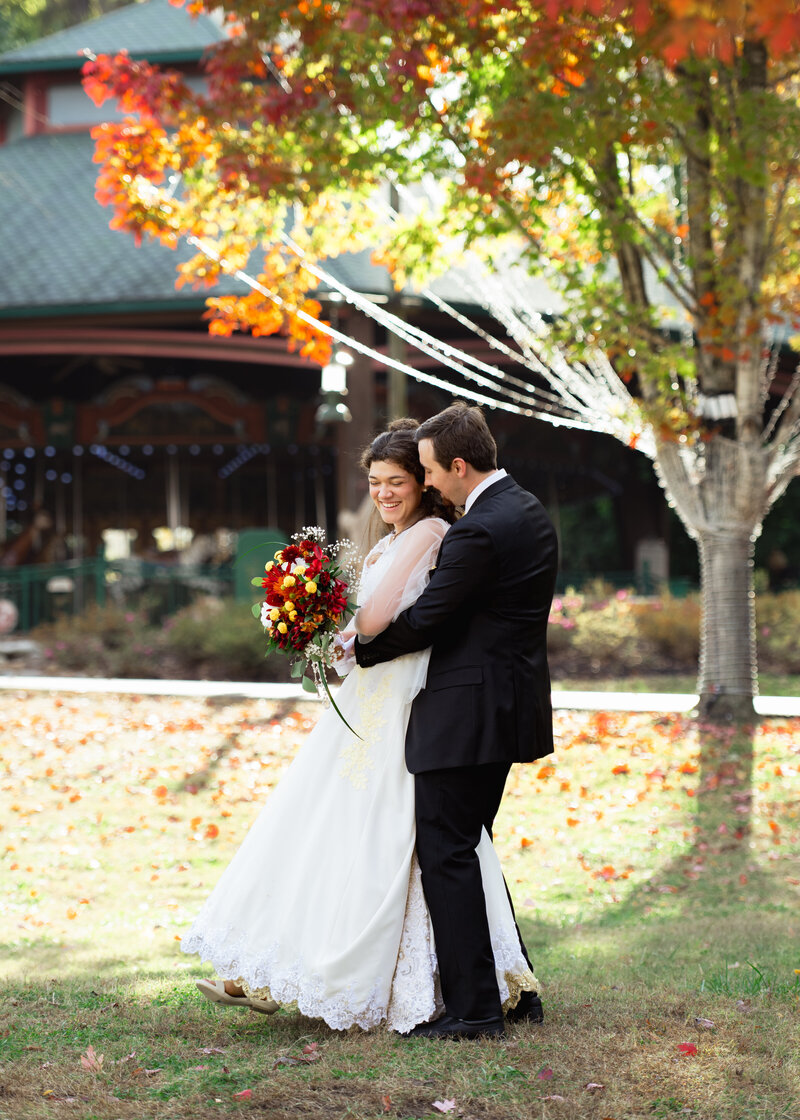 A catholic couple dances together at the nashville Zoo during colorful and whimsical couple's portraits after their traditional catholic wedding Mass at St. Mary's Catholic Church in downtown Nashville