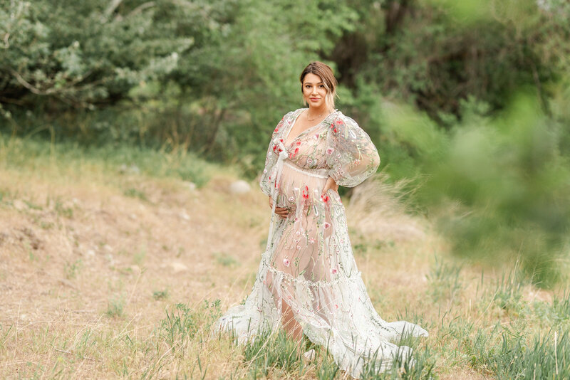 pregnant mom wearing stunning floral gown amongst the okanagan landscapes