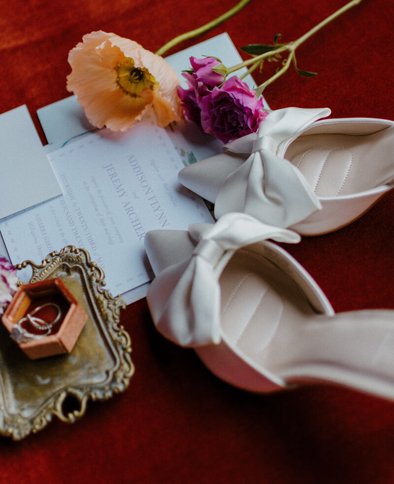 Flat lay details with florals, ring and shoes. 