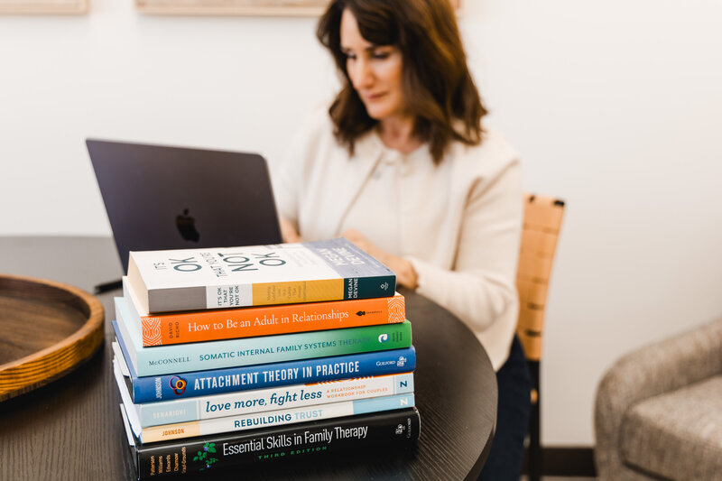 a stack of books on a therapist's desk