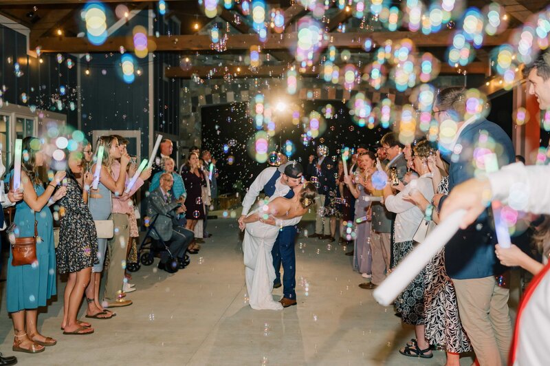 This wedding film frame grab from Films by Brian, a Williamsburg, VA-based destination wedding videographer, shows a beautiful bride being dipped and kissed by her groom in Williamsburg Virginia, while bubbles fly in the foreground.
