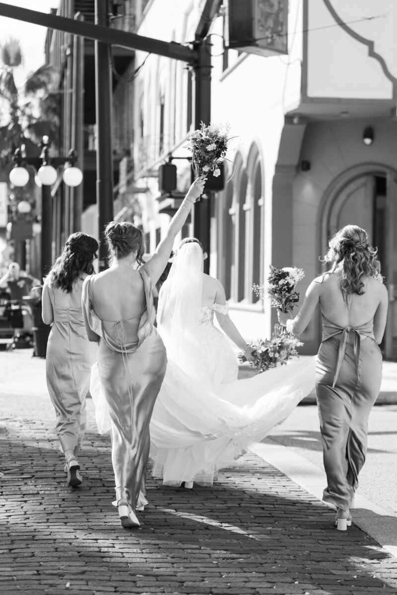 bride and bridesmaids walking across the street
