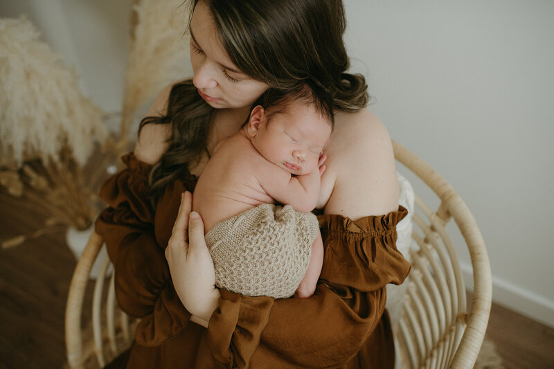 Vancouver newborn curled on moms chest