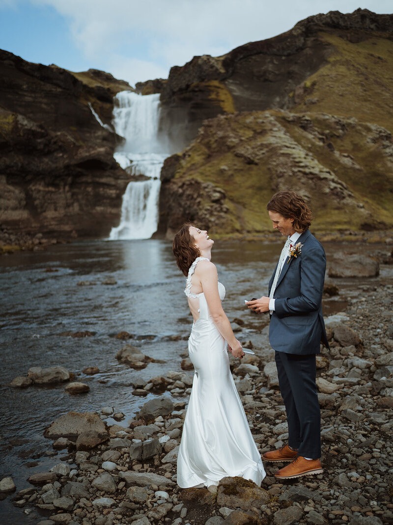 bride and groom standing in red rocks