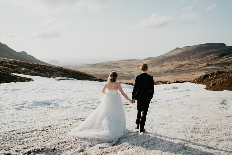 Brie and groom hold hands while walking across the salt flats in Iceland during their adventure elopement. 