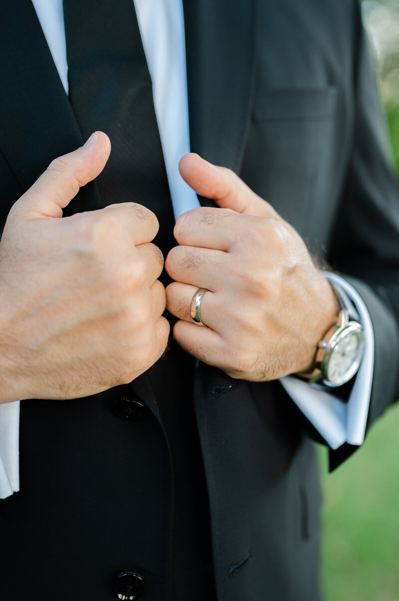 close up photo of groom holding his lapels